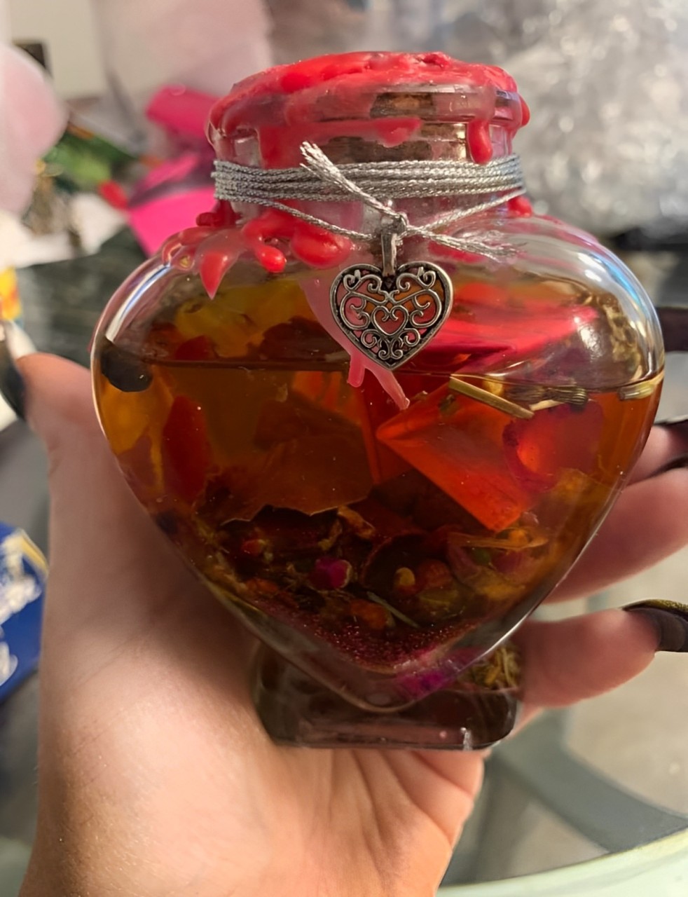 A Hand Holds a Glass Jar Topped With a Heart-Shaped Lid